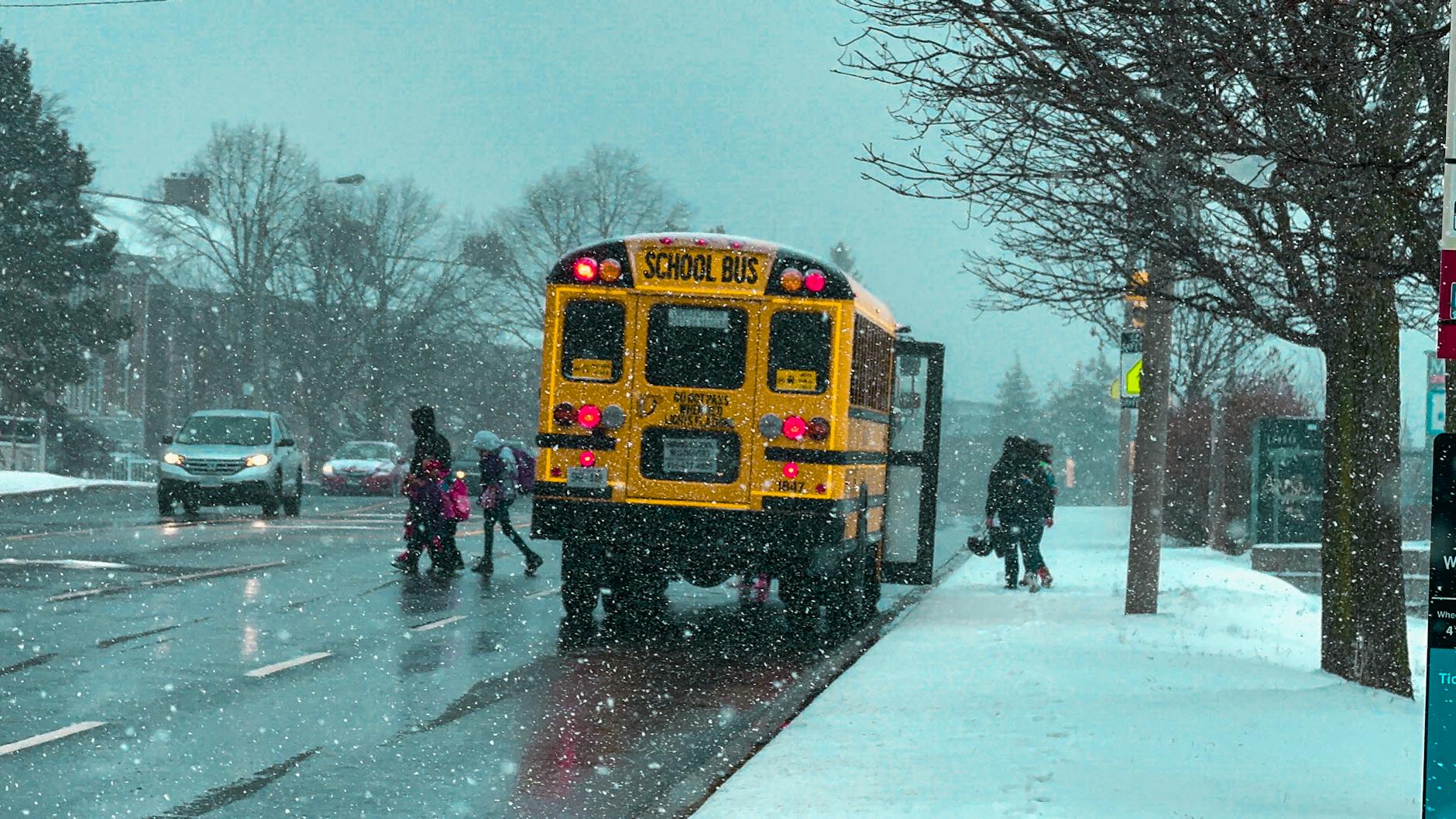children boarding school bus in winter snow