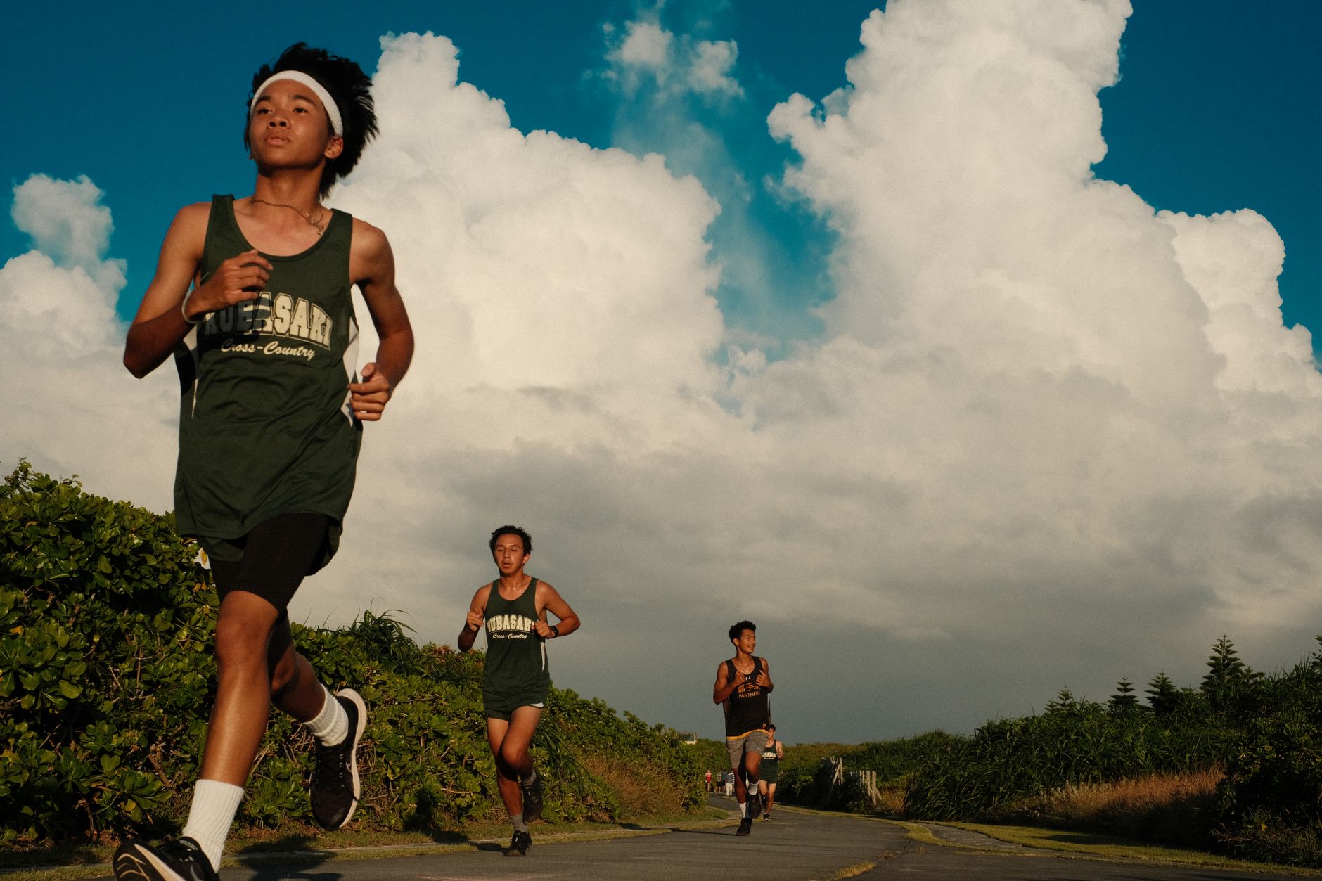 teenage boys running outdoors on sunny day